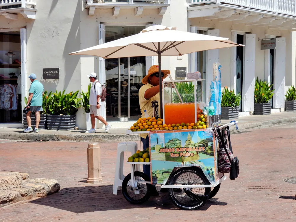 Vendedor de jugos naturales con su carreta de naranjas en una calle del centro de Cartagena
